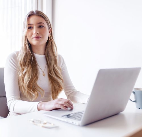 Young blond woman working on her laptop at the office